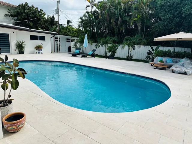 a view of swimming pool with outdoor seating and plants