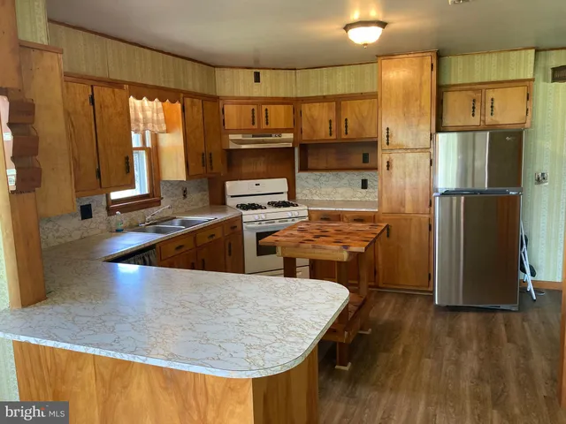 a kitchen with stainless steel appliances granite countertop a refrigerator and a sink
