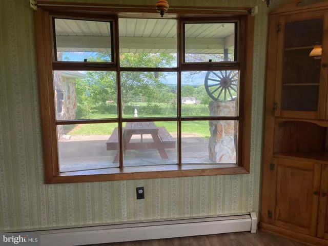a view of an empty room with a window and fireplace