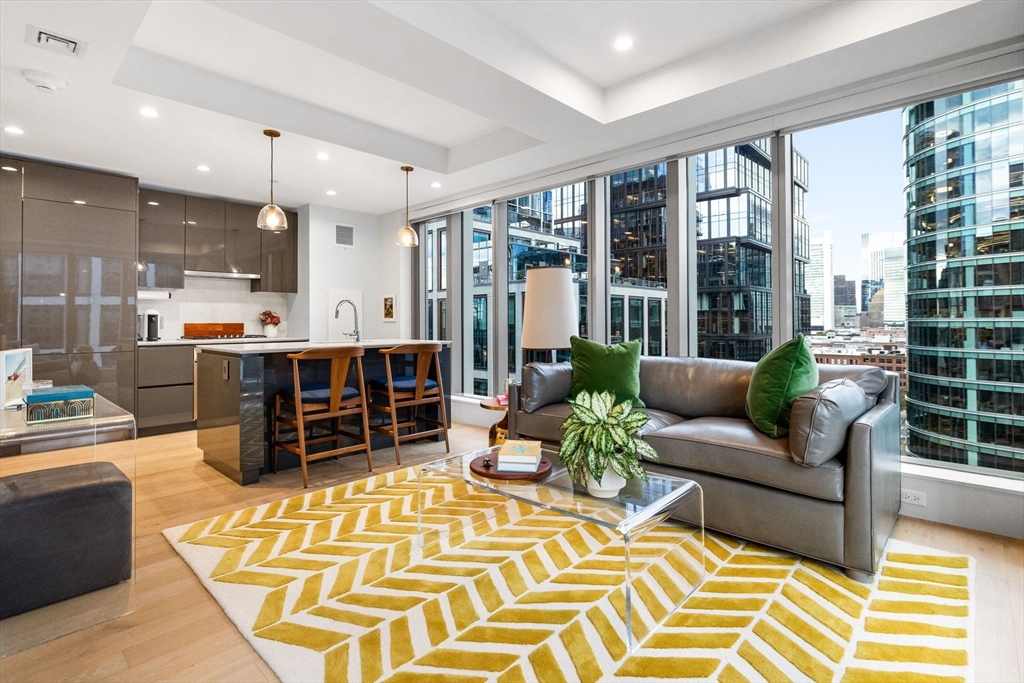 a living room with furniture a flat screen tv and large windows