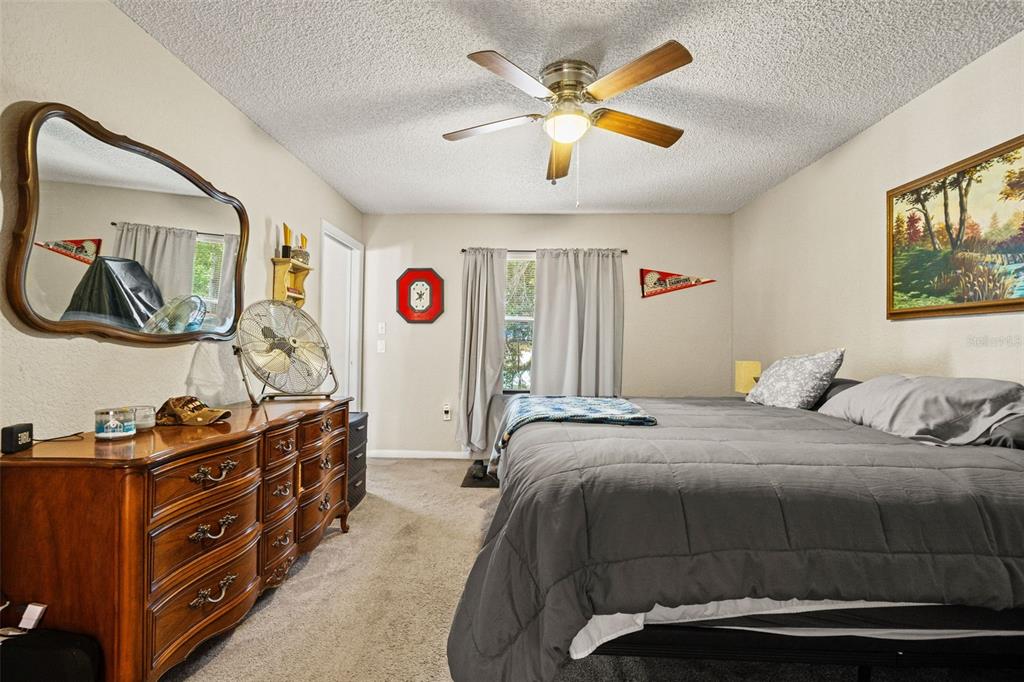 12292 Ronald Street Spring Hill, FL 34609 - Photo 10 of 18 a bedroom with a bed and a chandelier
