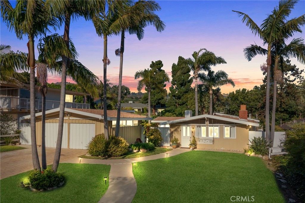 a front view of a house with garden and swimming pool