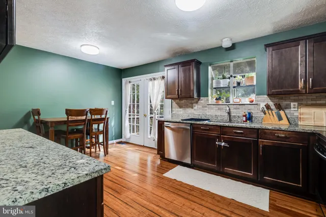 a kitchen with stainless steel appliances granite countertop a stove top oven a sink and dishwasher
