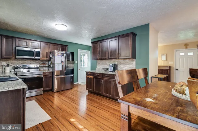 a kitchen with a sink cabinets and wooden floor