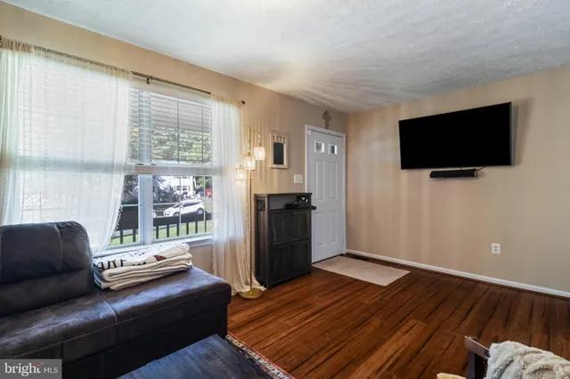 a kitchen with stainless steel appliances granite countertop a stove a sink dishwasher a microwave oven and a dining table with wooden floor