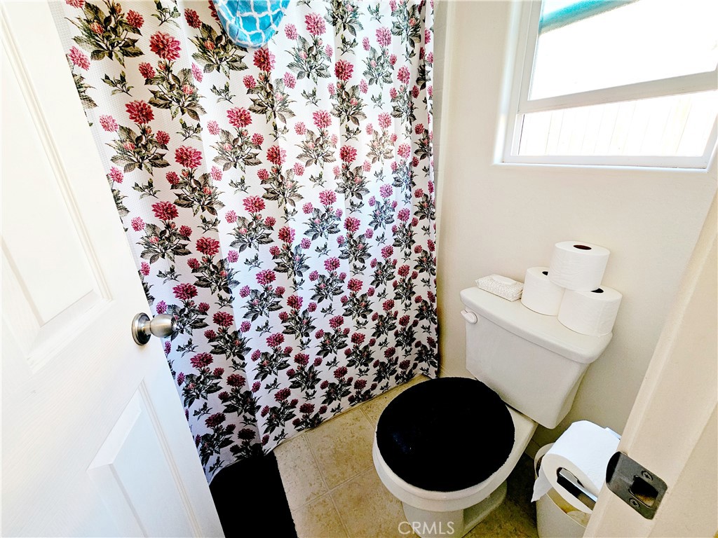 301 Moonstone Beach Court Delano, CA 93215 - Photo 20 of 31 a bathroom with a toilet and a shower curtain