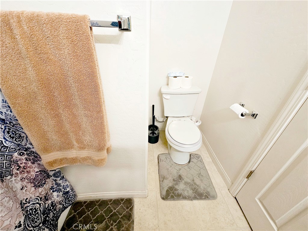 301 Moonstone Beach Court Delano, CA 93215 - Photo 26 of 31 a bathroom with a toilet and a shower curtain