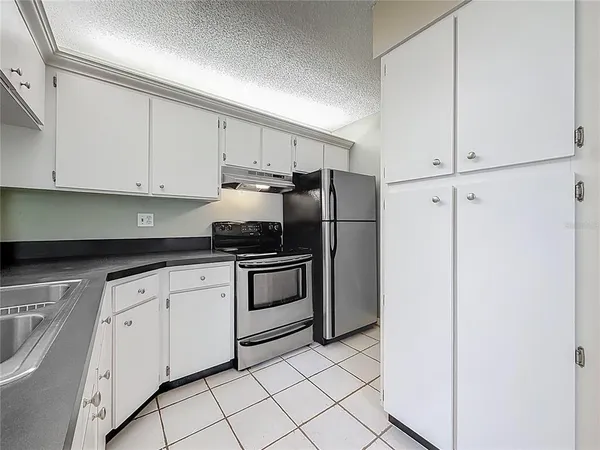 a kitchen with granite countertop white cabinets stainless steel appliances and sink