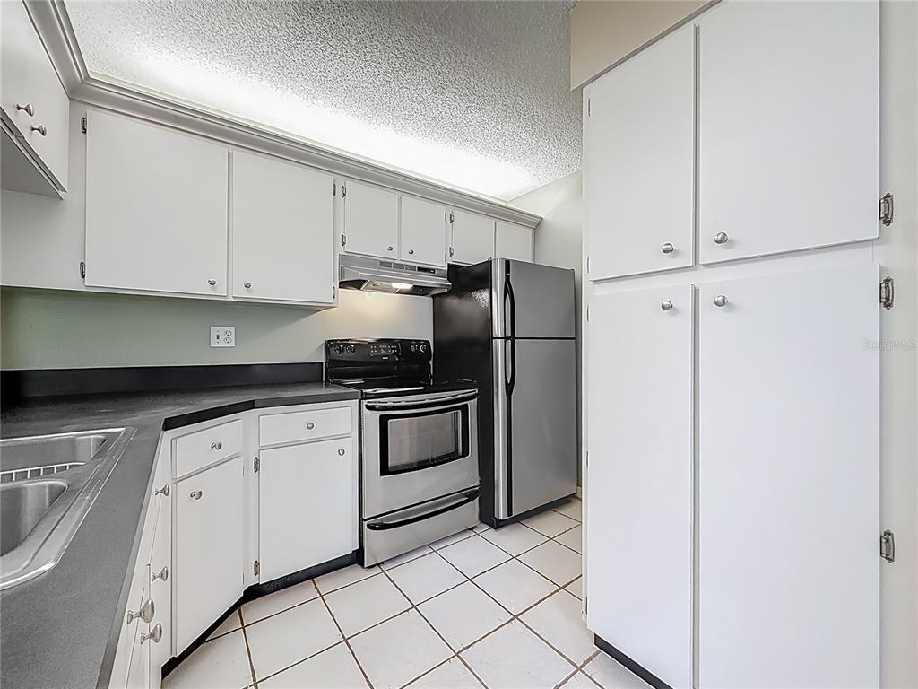1372 Pine Ridge Circle East, Unit H3 Tarpon Springs, FL 34688 - Photo 13 of 53 a kitchen with cabinets and appliances