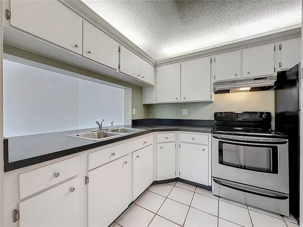 a kitchen with granite countertop white cabinets and appliances