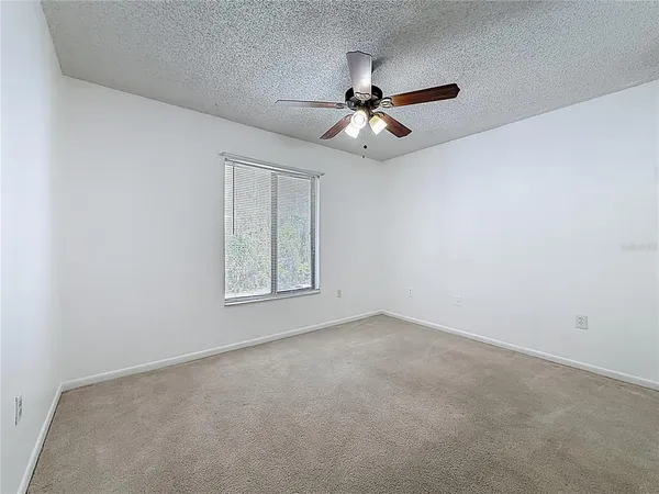 an empty room with closet and ceiling fan