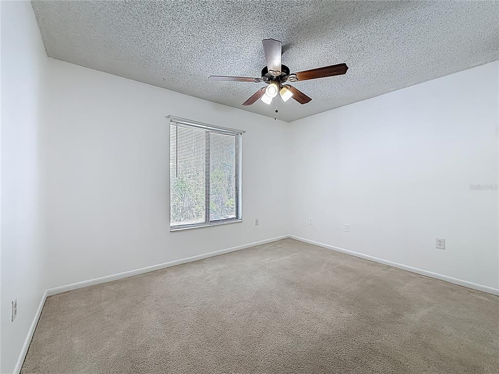 1372 Pine Ridge Circle East, Unit H3 Tarpon Springs, FL 34688 - Photo 19 of 53 an empty room with windows and fan