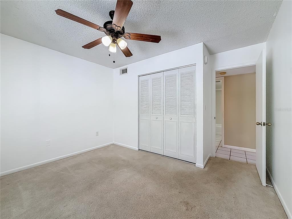 1372 Pine Ridge Circle East, Unit H3 Tarpon Springs, FL 34688 - Photo 20 of 53 an empty room with chandelier fan