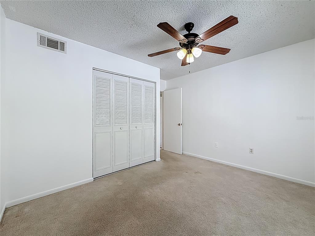 1372 Pine Ridge Circle East, Unit H3 Tarpon Springs, FL 34688 - Photo 21 of 53 an empty room with closet and ceiling fan