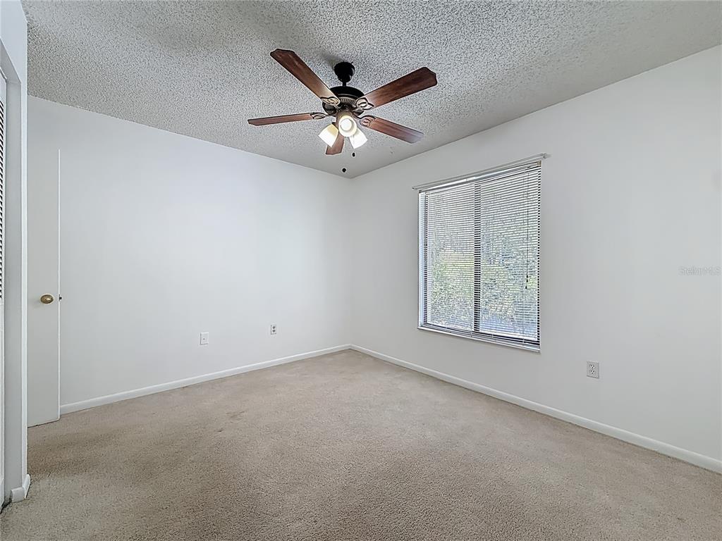 1372 Pine Ridge Circle East, Unit H3 Tarpon Springs, FL 34688 - Photo 22 of 53 an empty room with windows and fan