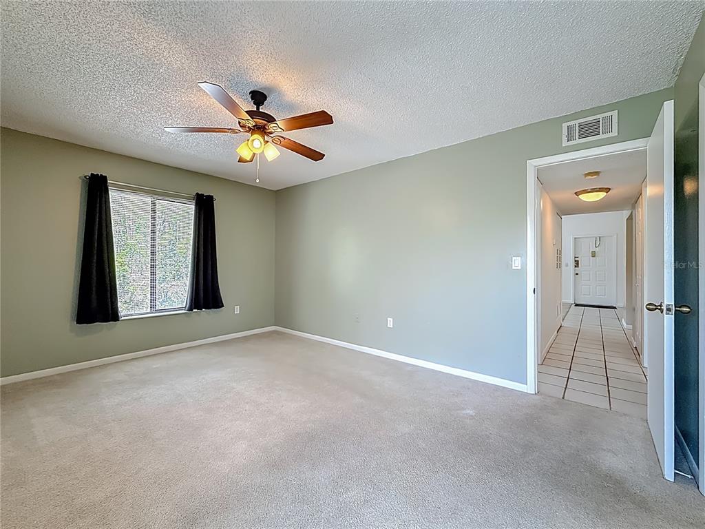1372 Pine Ridge Circle East, Unit H3 Tarpon Springs, FL 34688 - Photo 25 of 53 a view of an empty room with window and chandelier fan