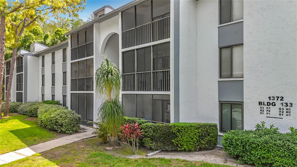 1372 Pine Ridge Circle East, Unit H3 Tarpon Springs, FL 34688 - Photo 3 of 53 a front view of a house with a garden