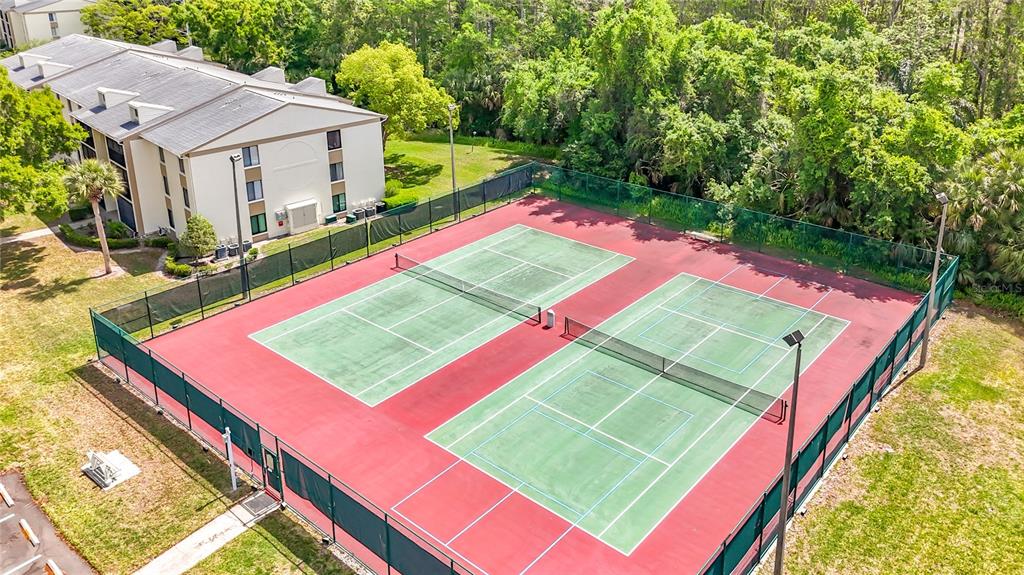 1372 Pine Ridge Circle East, Unit H3 Tarpon Springs, FL 34688 - Photo 46 of 53 a view of a tennis ground with a big yard