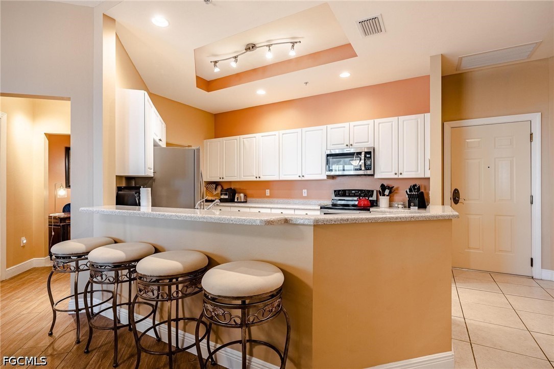 2745 First Street, Unit 306 Fort Myers, FL 33916 - Photo 22 of 50 a kitchen with stainless steel appliances granite countertop a table chairs sink and cabinets