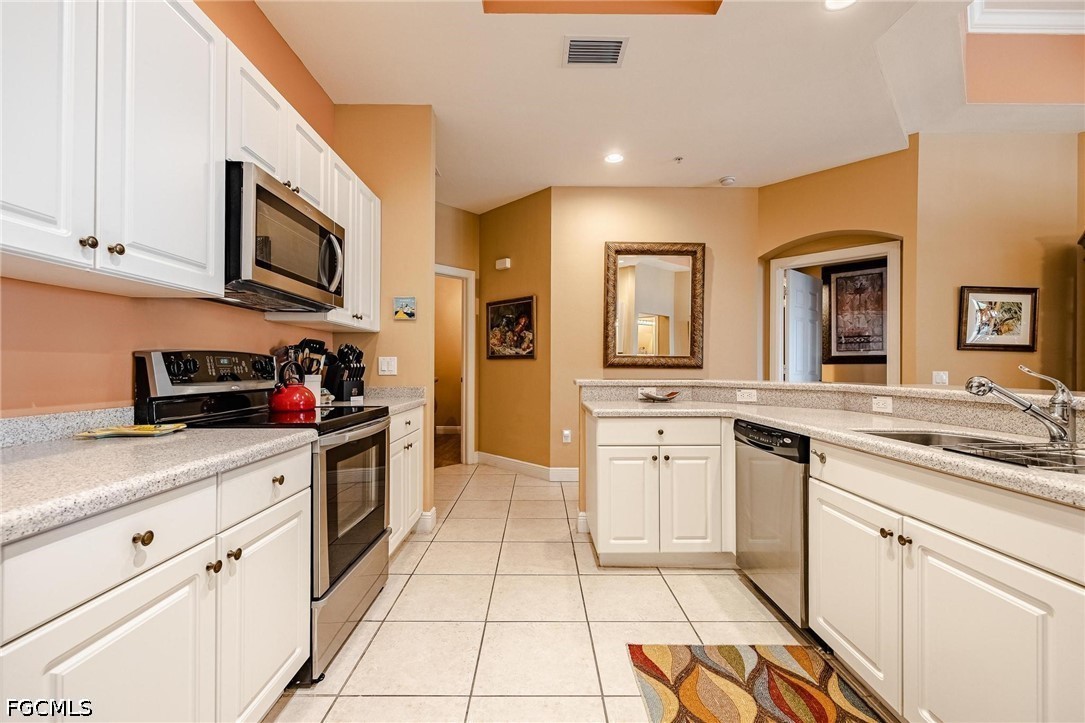 2745 First Street, Unit 306 Fort Myers, FL 33916 - Photo 24 of 50 a kitchen with stainless steel appliances granite countertop a sink and cabinets