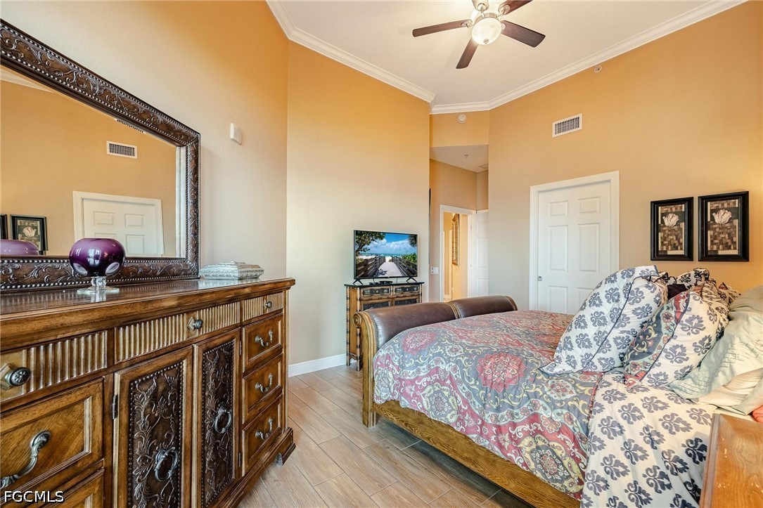 2745 First Street, Unit 306 Fort Myers, FL 33916 - Photo 6 of 50 a bedroom with a bed and a large mirror on the dresser with wooden floor