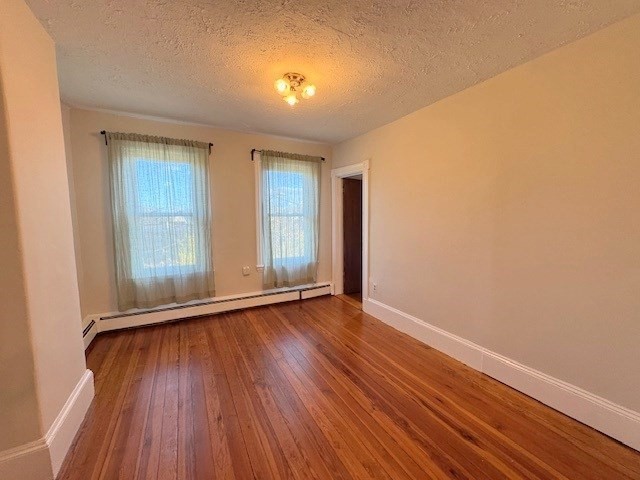 4 Mead Street, Unit 3 Boston, MA 02134 - Photo 11 of 20 an empty room with wooden floor and windows