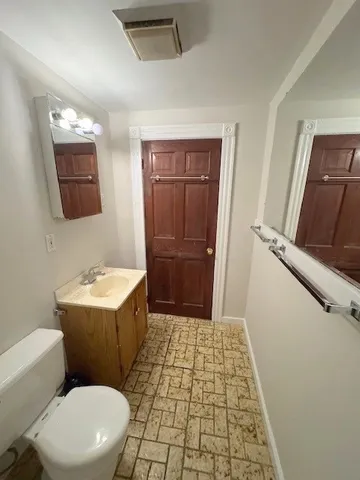 a bathroom with a sink a toilet a mirror and vanity