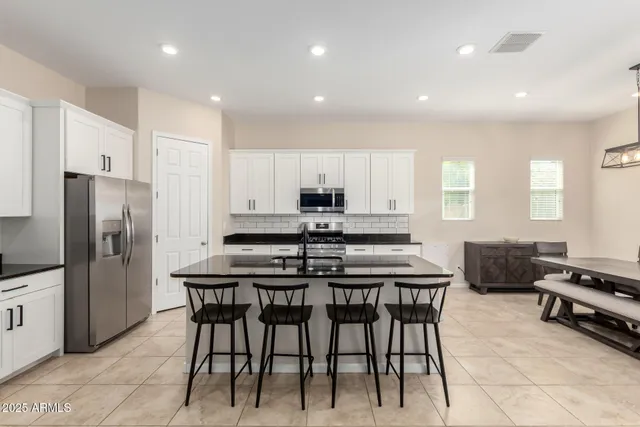 a kitchen with stainless steel appliances granite countertop a stove a sink a microwave and a refrigerator