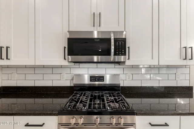 a kitchen with a sink and a stove top oven with wooden floor