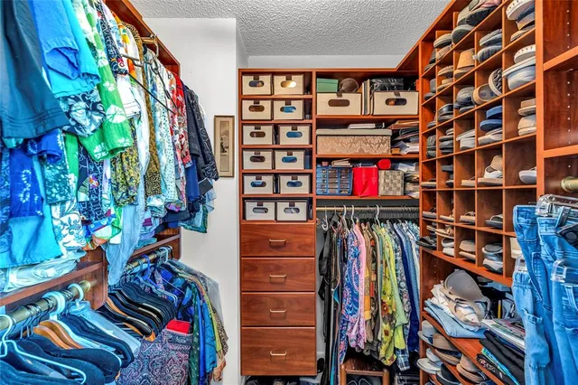 a view of walk in closet with clothes