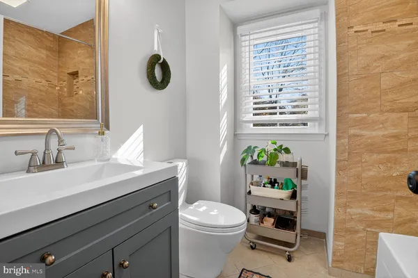 a bathroom with a sink a toilet and a mirror