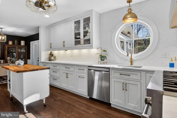 a kitchen with stainless steel appliances granite countertop a stove a sink and a chandelier