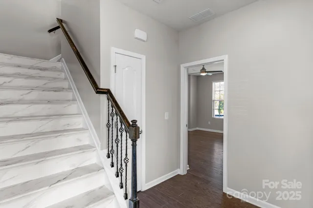 a view of a hallway with wooden floor and entryway