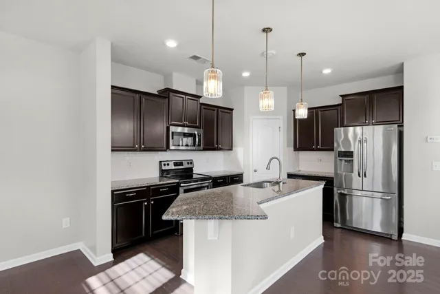 a kitchen with kitchen island a sink stainless steel appliances and cabinets