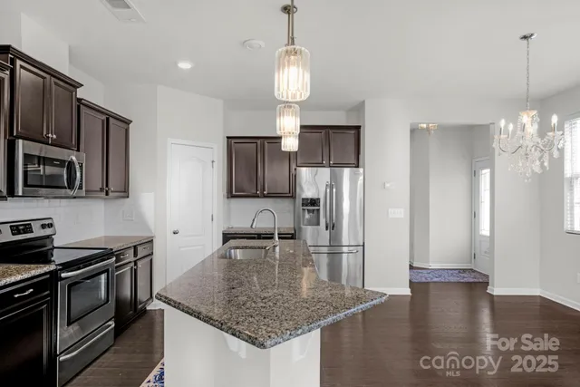 a kitchen with stainless steel appliances granite countertop a sink refrigerator and microwave