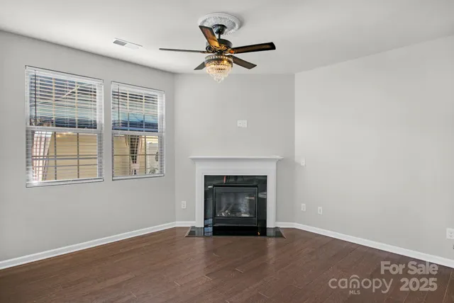 a view of an empty room with a fireplace and a window