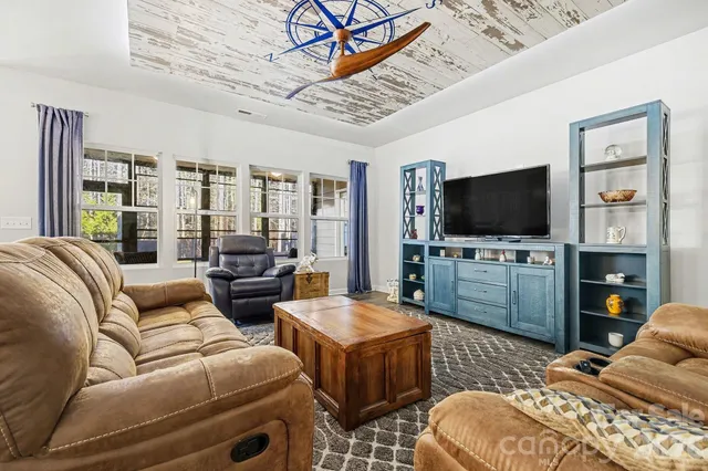 a living room with furniture kitchen view and large windows