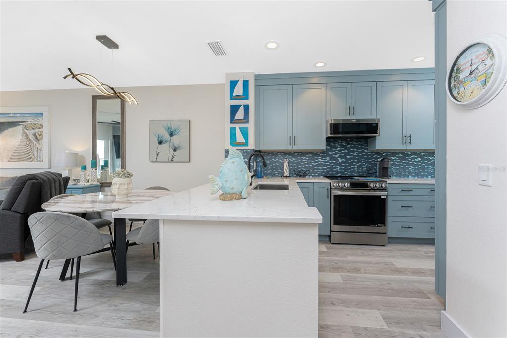 8405 Placida Road, Unit 406 Placida, FL 33946 - Photo 7 of 55 a kitchen with kitchen island granite countertop a sink cabinets and stainless steel appliances