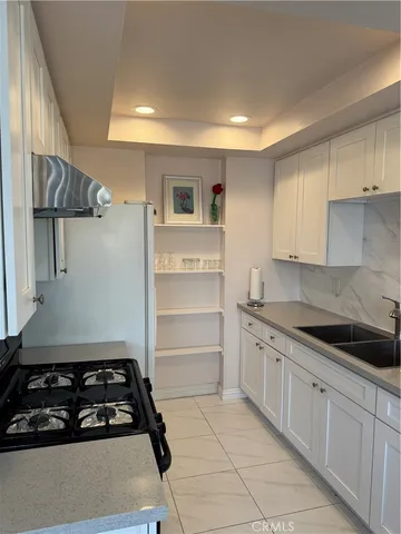 a kitchen with white cabinets and appliances