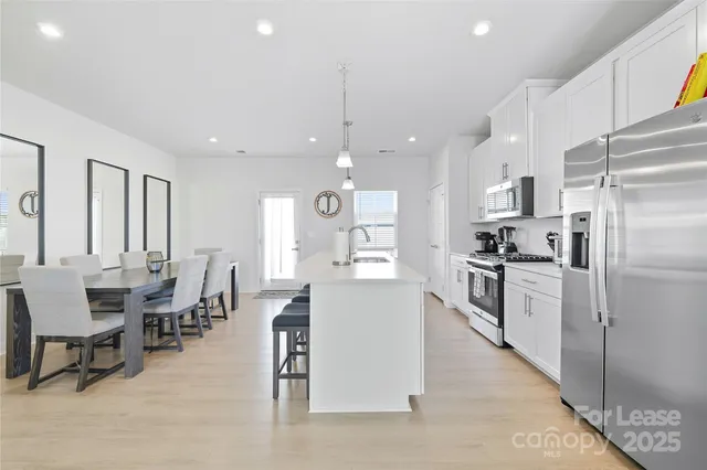 a large kitchen with stainless steel appliances granite countertop a lot of counter space and wooden floors