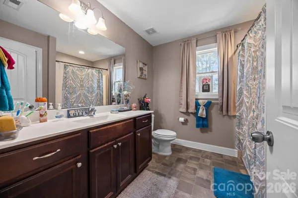 a spacious bathroom with a sink a toilet and a mirror