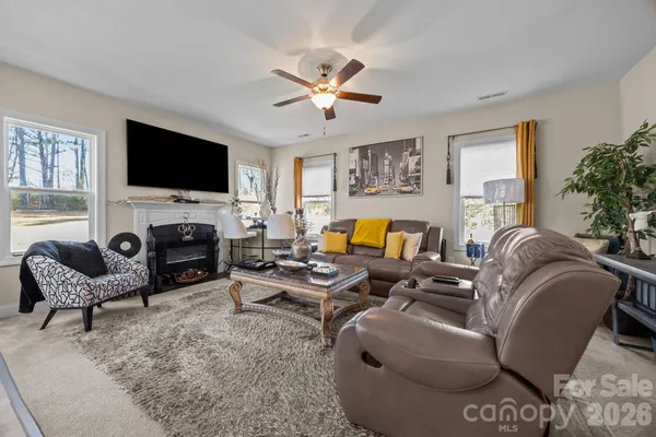 a living room with furniture a fireplace and a flat screen tv