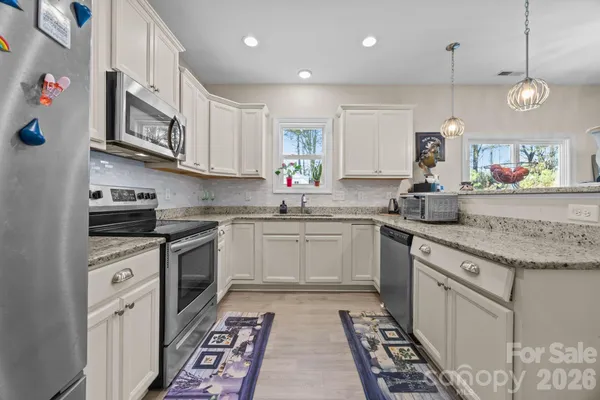 a kitchen with stainless steel appliances granite countertop a sink stove and cabinets