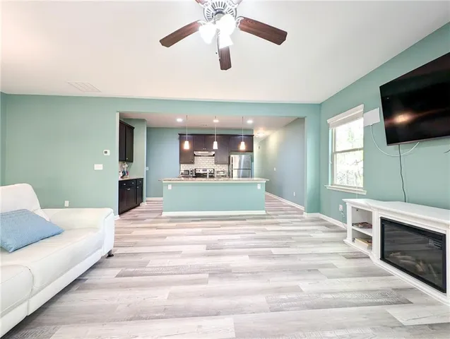 a bed room with a bed couches and a flat tv screen