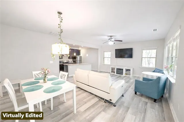 a kitchen with stainless steel appliances granite countertop a refrigerator a sink a stove and a wooden floors