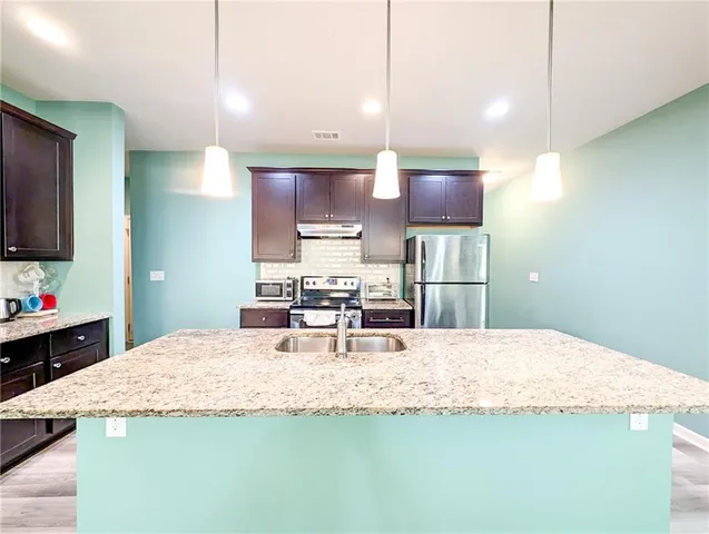 a kitchen with kitchen island a counter top space appliances and cabinets
