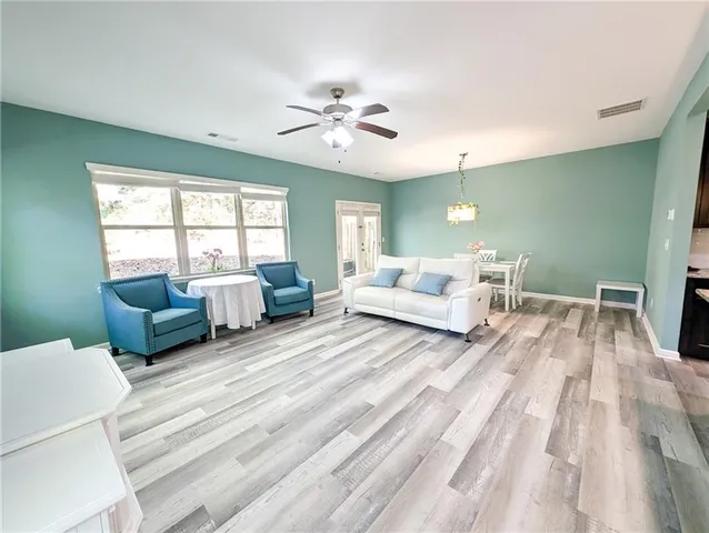 a living room with furniture and a view of kitchen