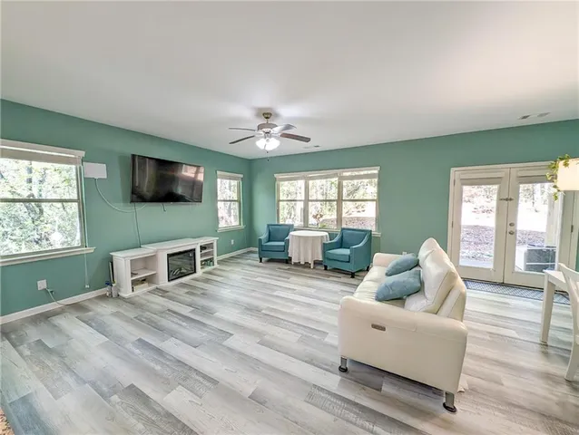 a living room with furniture a flat screen tv and a fireplace