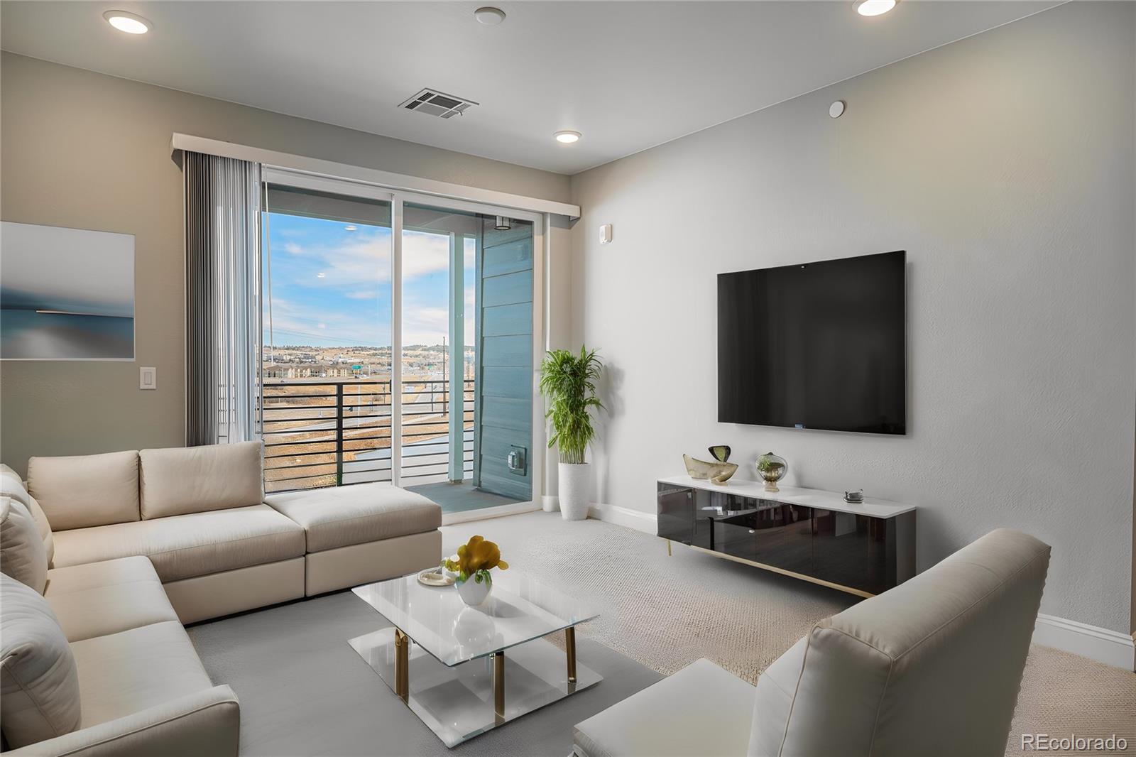 16881 Askins Loop, Unit 302 Parker, CO 80134 - Photo 4 of 11 a living room with furniture and a flat screen tv