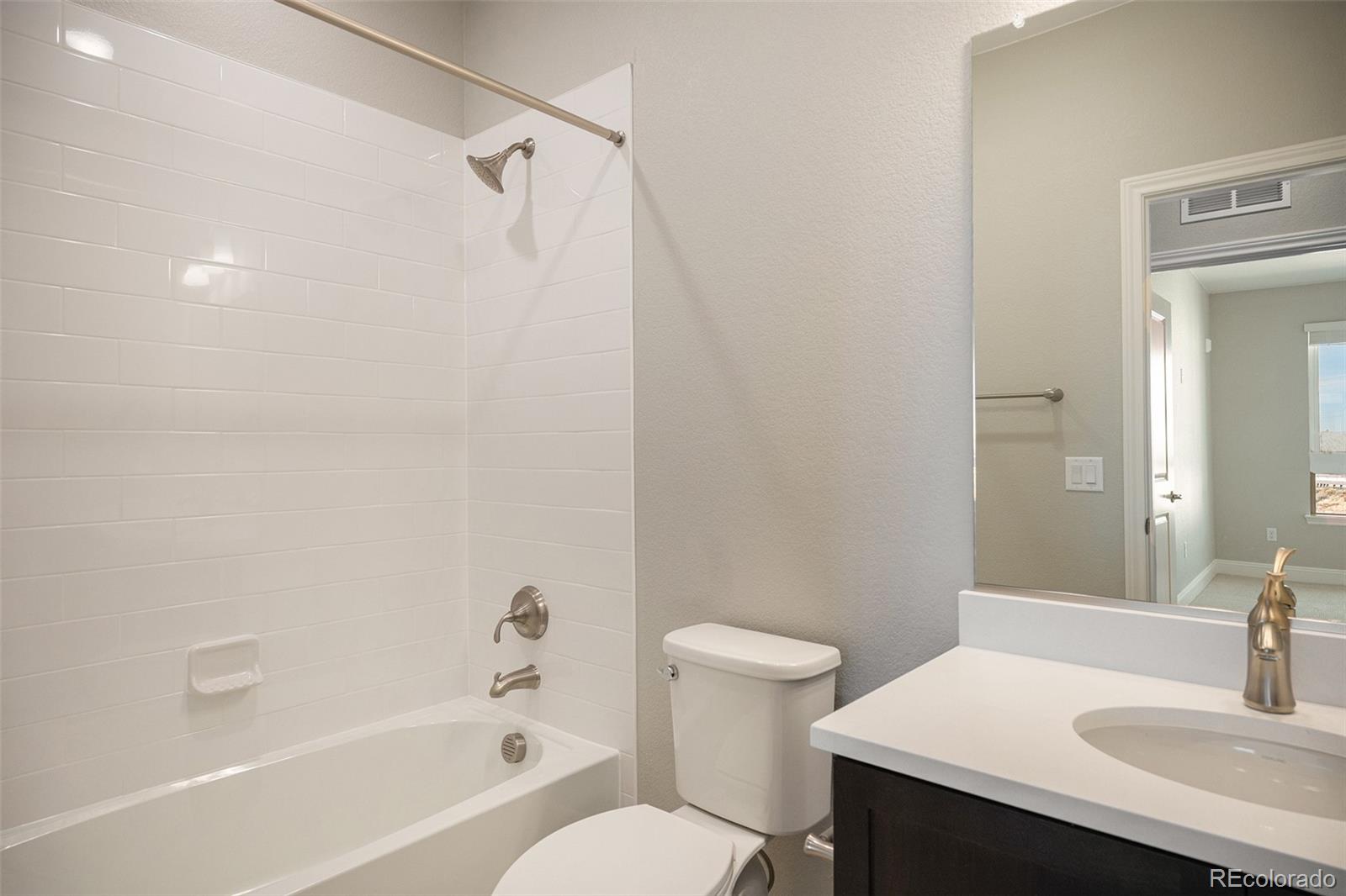 16881 Askins Loop, Unit 302 Parker, CO 80134 - Photo 6 of 11 a bathroom with a sink a toilet and shower